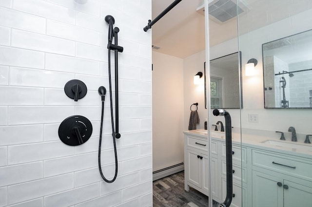 bathroom featuring hardwood / wood-style floors, vanity, and a baseboard heating unit