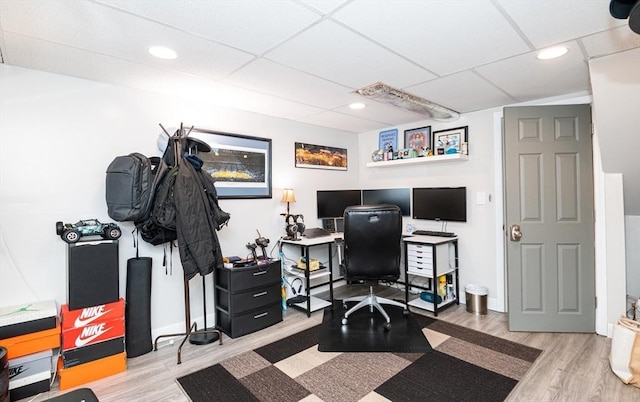 home office with a paneled ceiling and wood-type flooring