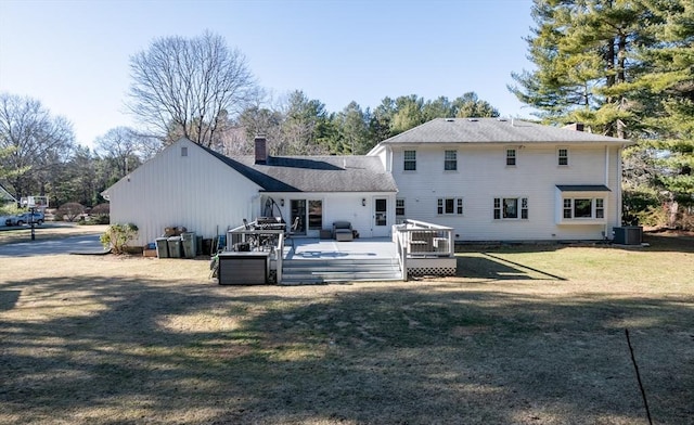 back of house featuring a lawn, a wooden deck, and central AC