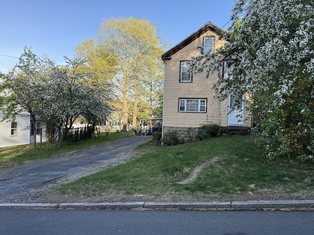 view of home's exterior with driveway and a lawn