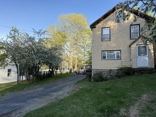 view of home's exterior featuring driveway and a lawn