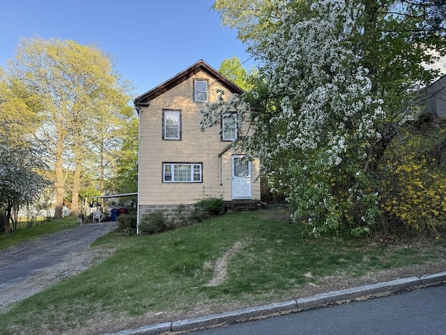 view of front of house with a front lawn, an attached carport, and aphalt driveway