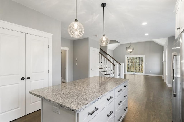 kitchen with lofted ceiling, dark wood-type flooring, stainless steel refrigerator with ice dispenser, and a center island