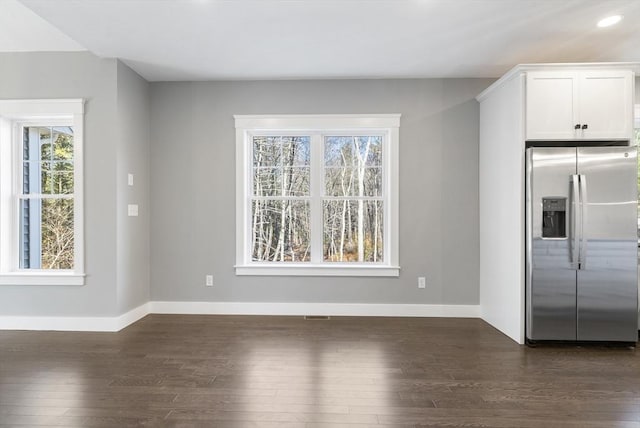 unfurnished dining area featuring dark wood-style floors, baseboards, and recessed lighting