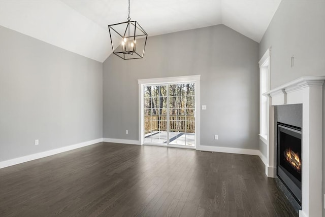 unfurnished dining area featuring lofted ceiling, a warm lit fireplace, baseboards, and dark wood-style flooring