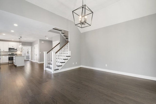 interior space featuring dark wood-style flooring, recessed lighting, an inviting chandelier, baseboards, and stairs