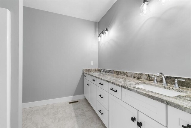 full bathroom with visible vents, a sink, baseboards, and double vanity