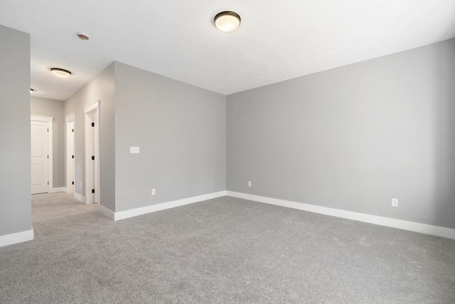 unfurnished room featuring carpet floors and baseboards