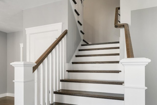 stairway with baseboards and wood finished floors