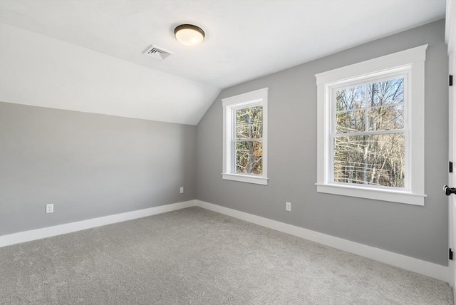 bonus room with a wealth of natural light, visible vents, vaulted ceiling, and baseboards