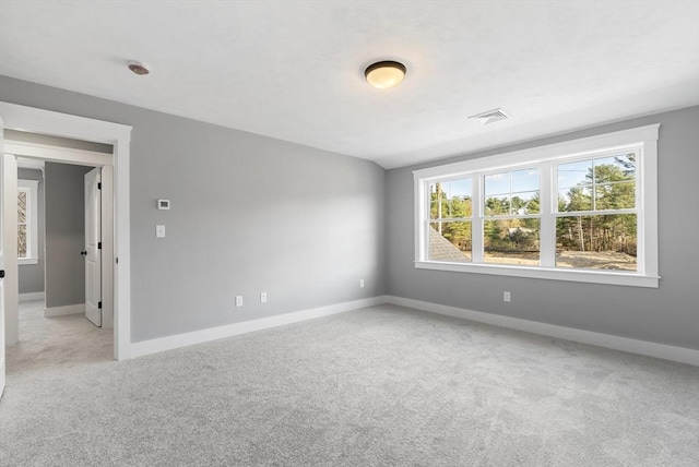 spare room featuring light carpet, baseboards, and visible vents