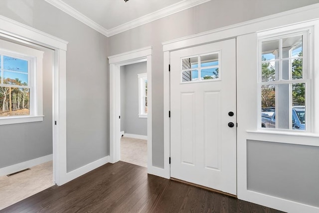 foyer entrance with dark wood-style floors, baseboards, visible vents, and crown molding