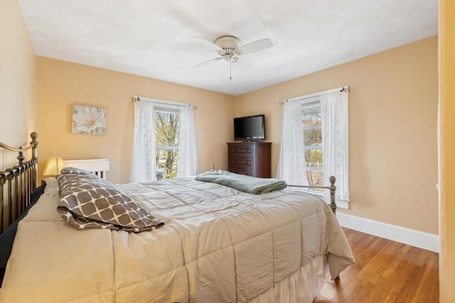 bedroom with baseboards, ceiling fan, and wood finished floors