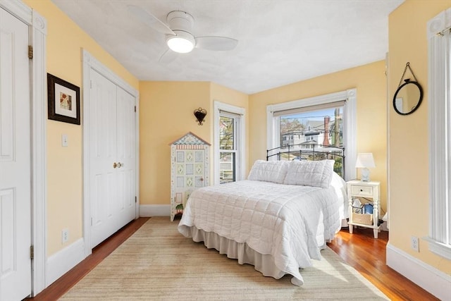 bedroom with baseboards, ceiling fan, and wood finished floors