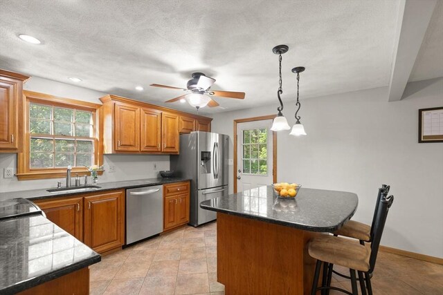 6 2nd Ave, Wilmington, MA 01887 - kitchen featuring stainless steel appliances, a sink, brown cabinets, a kitchen bar, and a center island