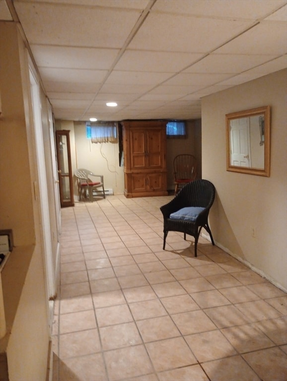 sitting room with a drop ceiling and light tile patterned flooring