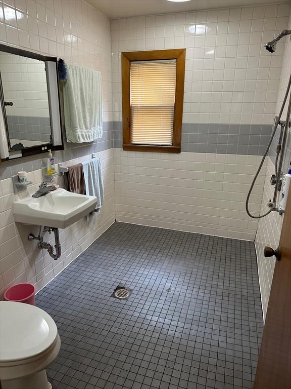 41 Mayland St, Fitchburg, MA 01420 - bathroom featuring tile walls, a tile shower, toilet, a sink, and tile patterned floors