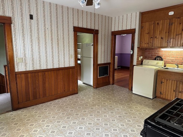 41 Mayland St, Fitchburg, MA 01420 - kitchen with washer / clothes dryer, freestanding refrigerator, a wainscoted wall, a sink, and black gas range