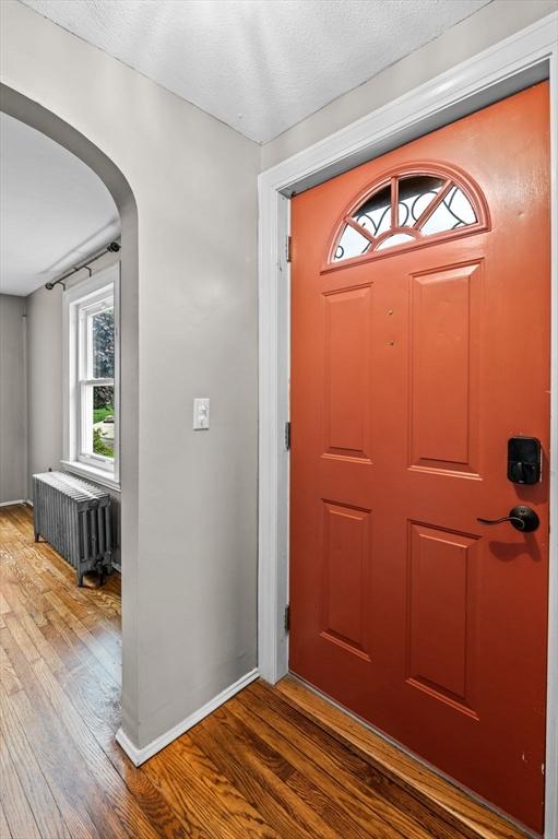 7 Beaver St, Beverly, MA 01915 - entryway featuring radiator, wood finished floors, arched walkways, and baseboards