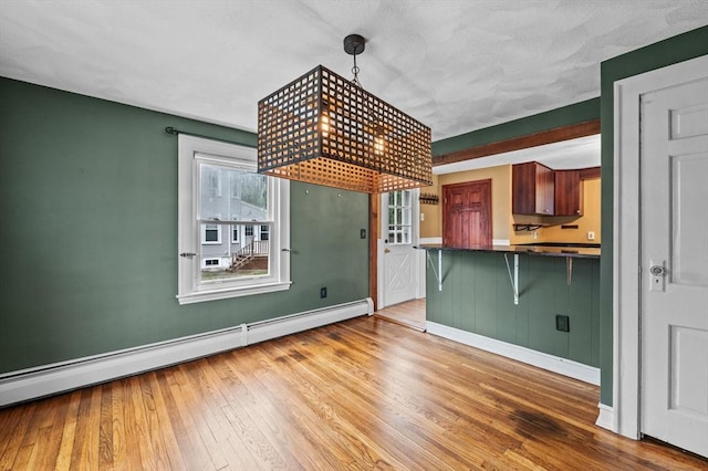 7 Beaver St, Beverly, MA 01915 - kitchen with dark countertops, hardwood / wood-style floors, baseboards, and a kitchen bar