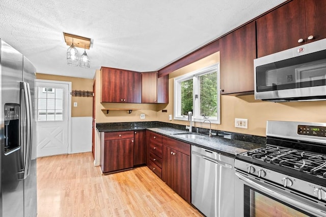 7 Beaver St, Beverly, MA 01915 - kitchen with appliances with stainless steel finishes, light wood-style floors, a sink, a wainscoted wall, and dark stone counters