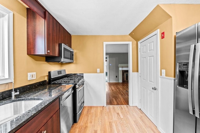 7 Beaver St, Beverly, MA 01915 - kitchen featuring appliances with stainless steel finishes, light wood-type flooring, dark stone counters, a sink, and wainscoting