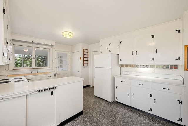 kitchen featuring freestanding refrigerator, white cabinets, and light countertops