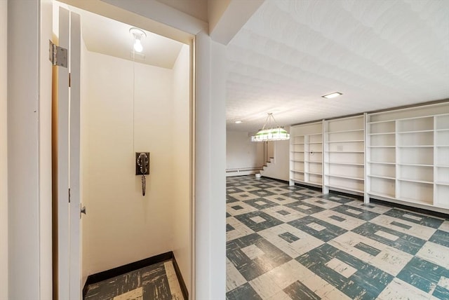 corridor with tile patterned floors, baseboard heating, and baseboards