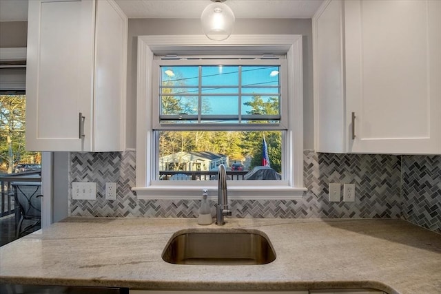 kitchen with a sink, white cabinetry, and a healthy amount of sunlight