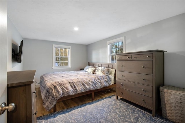 bedroom with multiple windows and dark wood finished floors