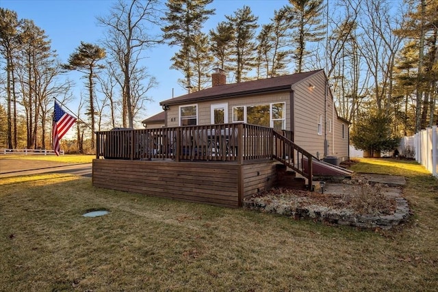 view of front of home featuring a front yard, a chimney, fence, and a deck