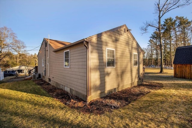 view of side of property featuring a yard and central AC unit