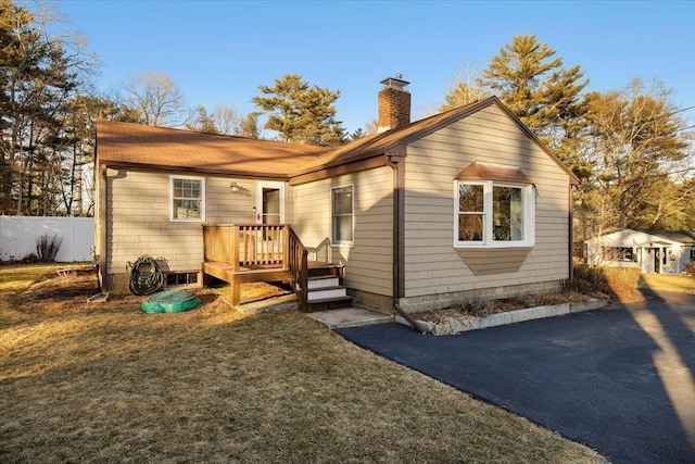 rear view of property with fence and a chimney