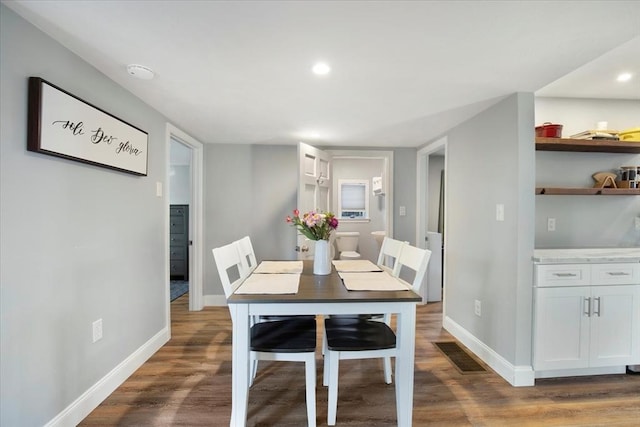 dining space with recessed lighting, wood finished floors, visible vents, and baseboards