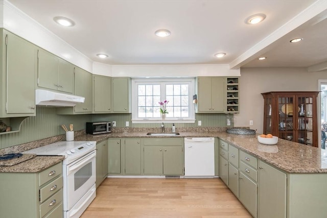 kitchen featuring a sink, a peninsula, white appliances, green cabinetry, and under cabinet range hood