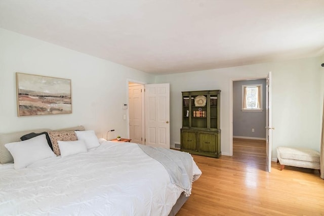 bedroom featuring light wood-style flooring and baseboards