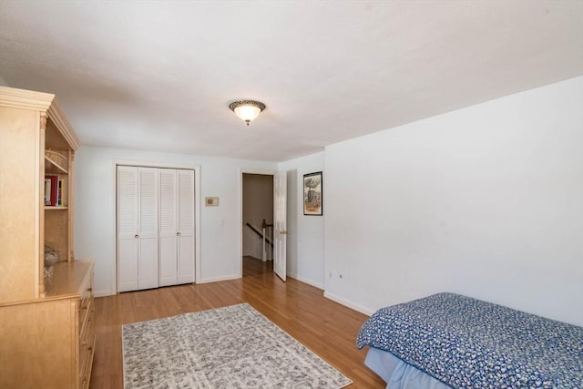 bedroom featuring a closet, baseboards, and wood finished floors