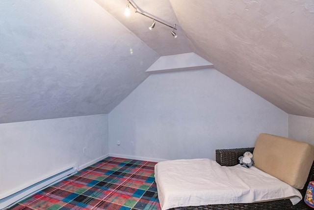 bedroom with lofted ceiling, a baseboard radiator, baseboards, dark carpet, and track lighting