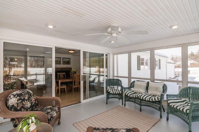 sunroom / solarium featuring a ceiling fan