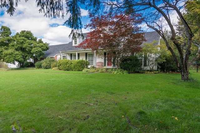 new england style home featuring a front lawn