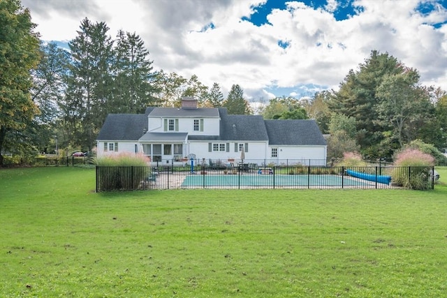 exterior space with a fenced in pool, fence, and a lawn