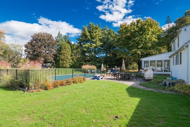 view of yard with a sunroom, a patio, fence, and a fenced in pool