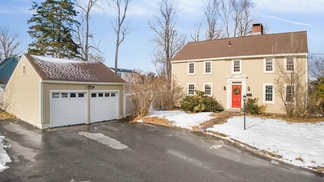 colonial-style house with a garage and an outbuilding