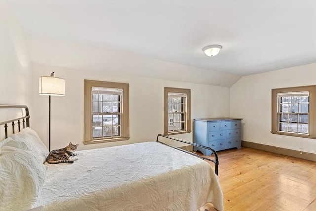 bedroom with vaulted ceiling and light wood-type flooring