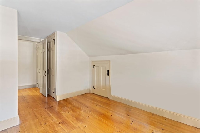 bonus room with lofted ceiling and hardwood / wood-style floors