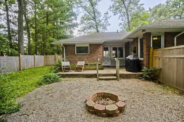 115 Carnavon Cir, Springfield, MA 01109 - back of house featuring a patio area, brick siding, a fenced backyard, and a fire pit