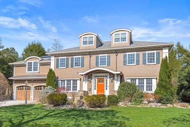 25 Wedgemere Ave, Winchester, MA 01890 - view of front of home with a front yard, an attached garage, driveway, and stone siding