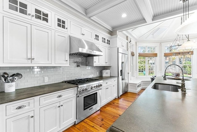 25 Wedgemere Ave, Winchester, MA 01890 - kitchen featuring premium appliances, under cabinet range hood, a sink, dark countertops, and crown molding