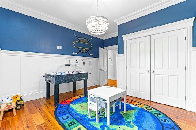 25 Wedgemere Ave, Winchester, MA 01890 - recreation room with a chandelier, ornamental molding, wood finished floors, a wainscoted wall, and a decorative wall