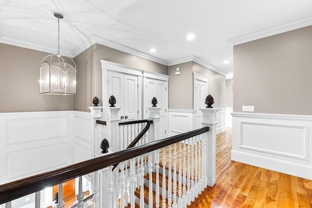 25 Wedgemere Ave, Winchester, MA 01890 - hall with an upstairs landing, a decorative wall, crown molding, light wood-type flooring, and a chandelier